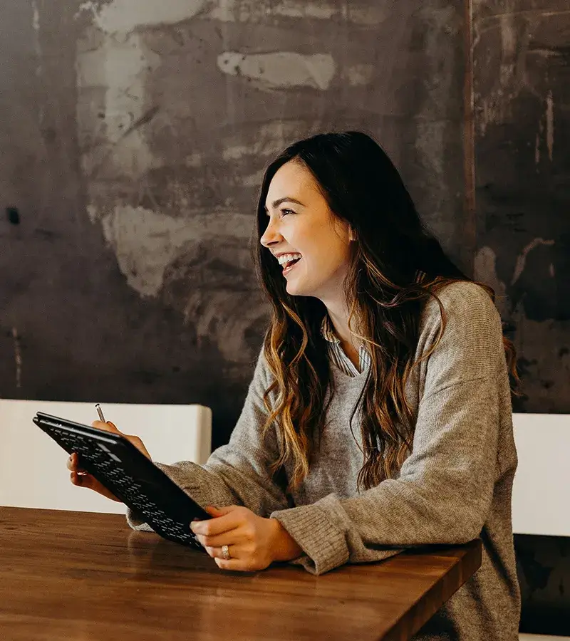 Finance-Be-Transparent A young woman smiling while working on her tablet