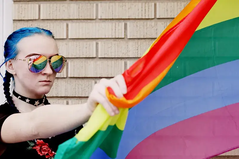 teen-with-flag A teenager holding a rainbow flag