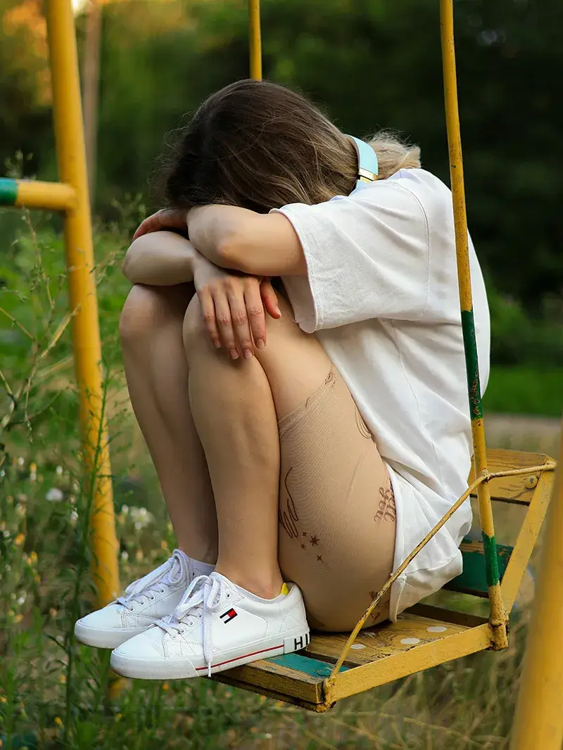 partner-violence-teen A teen girl hiding her face in her knees