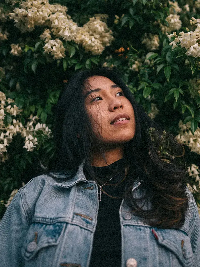 Girl standing in front of flowers