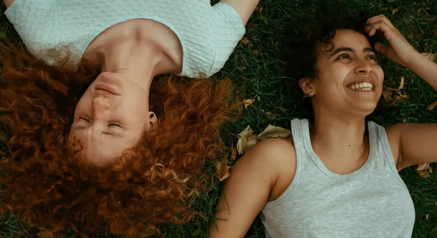 Two young people laying in the grass