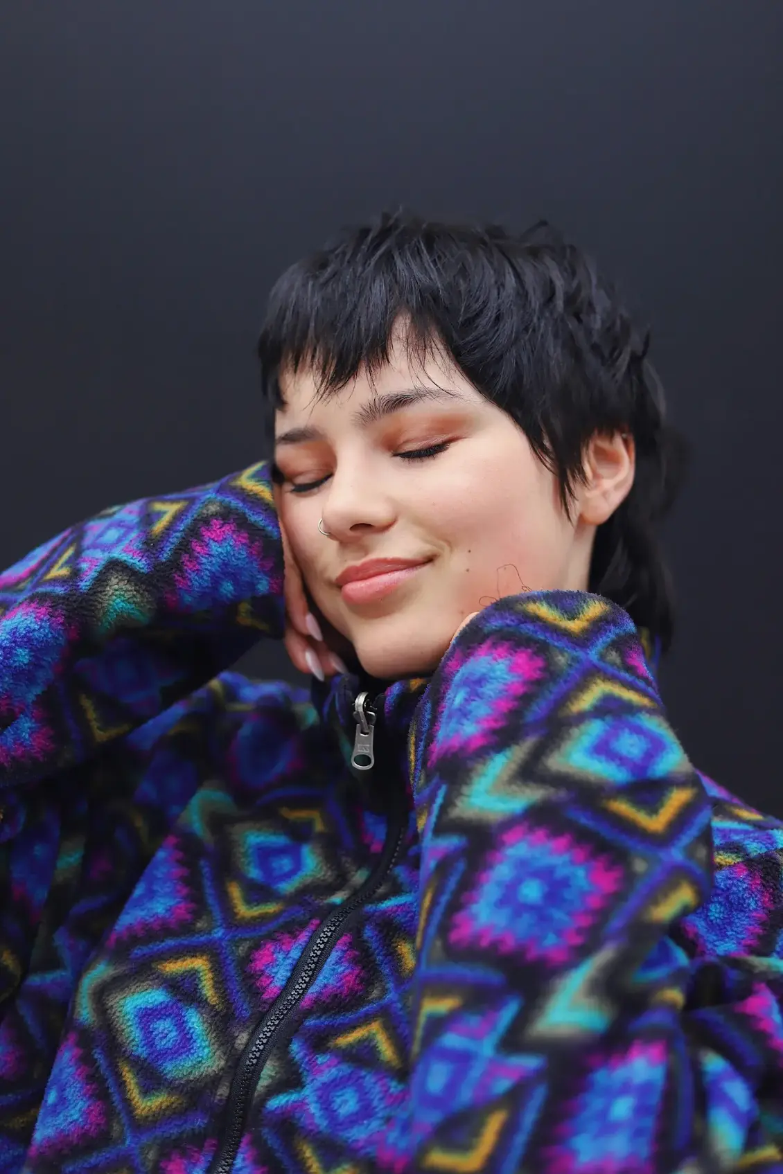 A young woman smiling with her eyes closed