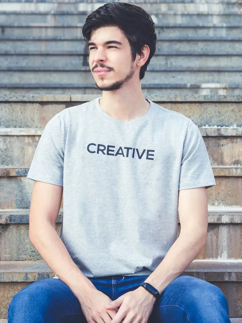 A teenage boy wearing a grey shirt that says "Creative"