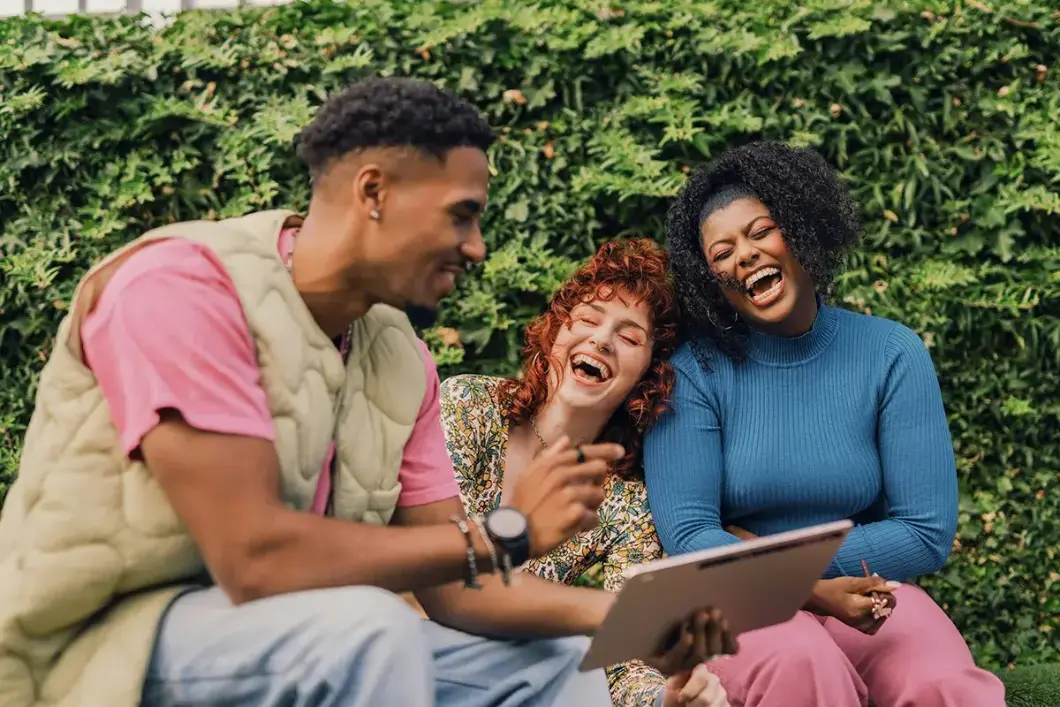 Three young adults laughing together